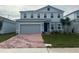 Two-story house with gray siding, brick driveway, and landscaping at 260 Crossings Ave, St Cloud, FL 34771