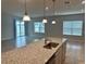 Kitchen island with granite countertops and view into Gathering room at 260 Crossings Ave, St Cloud, FL 34771