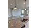 Kitchen island with granite countertops and stainless steel sink overlooking living room at 380 Crossings Ave, St Cloud, FL 34771