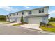 Townhouse style home with attached garage and landscaping at 6915 Five Oaks Dr, St Cloud, FL 34773