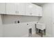 Bright laundry room with white cabinets and utility sink at 6915 Five Oaks Dr, St Cloud, FL 34773