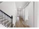 Bright hallway with hardwood floors, a staircase, and barn doors at 9432 Emerald Berry Dr, Winter Garden, FL 34787