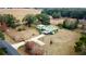Aerial view of a house, pool, and large lot with a long driveway at 13660 Se 80Th Ave, Summerfield, FL 34491