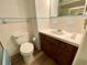 Bathroom with light blue tile and wood vanity at 13660 Se 80Th Ave, Summerfield, FL 34491