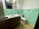 Small bathroom with mint green tile and vanity at 13660 Se 80Th Ave, Summerfield, FL 34491