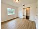 Spacious bedroom featuring wood-look floors and mirrored closet doors at 13660 Se 80Th Ave, Summerfield, FL 34491