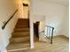 Indoor stairway with wood-look laminate flooring and simple railing at 13660 Se 80Th Ave, Summerfield, FL 34491
