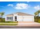 White two-story house with three-car garage and palm trees at 1912 Quail Fields Cir, Winter Haven, FL 33884