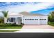 One-story home with gray exterior, two-car garage, and landscaping at 3036 Robles Rd, Clermont, FL 34711