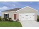 One-story home with two-car garage, landscaping, and neutral color palette at 310 Biltmore Blvd, Dundee, FL 33838