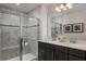 Modern bathroom featuring dual vanity, tiled shower with frameless glass, and decorative lighting at 3786 Sky Mountain Aly, Apopka, FL 32712