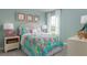 Bright bedroom with colorful bedding, white nightstands, and a window with natural light at 3786 Sky Mountain Aly, Apopka, FL 32712