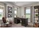Home office with a dark wood desk, comfortable seating, natural light, and decorative artwork at 3786 Sky Mountain Aly, Apopka, FL 32712