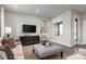 Living room with a sofa, ottoman, large TV, and hardwood floors at 3744 Sky Mountain Aly, Apopka, FL 32712