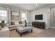 Spacious living room with beige sofa, ottoman, and large TV at 3744 Sky Mountain Aly, Apopka, FL 32712