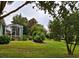 Lush backyard with a well-manicured lawn, mature trees, and a screened patio at 8320 Sw 82Nd Loop, Ocala, FL 34481