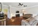 Spacious living room showcasing hardwood floors, a ceiling fan, and a cozy sectional, creating an inviting atmosphere at 8320 Sw 82Nd Loop, Ocala, FL 34481
