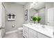 Bathroom featuring double sinks, a large mirror, and tiled shower, all in a neutral color scheme at 424 Hammock Oaks Blvd, Lady Lake, FL 32159