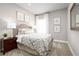 Cozy bedroom featuring neutral tones, patterned bedding, and a bedside table with a lamp at 424 Hammock Oaks Blvd, Lady Lake, FL 32159