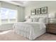 Serene bedroom with lake view, tray ceiling, light green walls and stylish furnishings at 424 Hammock Oaks Blvd, Lady Lake, FL 32159