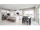 Open kitchen features modern appliances, white cabinets, island with seating, and adjacent dining area at 424 Hammock Oaks Blvd, Lady Lake, FL 32159