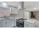 Bright kitchen features white cabinets, stainless steel appliances, and a view of the fireplace at 1360 10Th Ne Ct, Winter Haven, FL 33881