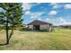 This barn with a metal roof sits on a grassy lot beneath a sunny sky at 5030 Alderman Rd, Lakeland, FL 33810