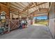 View of a barn interior featuring exposed beams, stalls, and ample space, ideal for various agricultural purposes at 5030 Alderman Rd, Lakeland, FL 33810