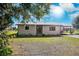 Charming single-story home with white brick and a covered carport set against a bright sky backdrop at 5030 Alderman Rd, Lakeland, FL 33810