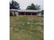 Rear view of a home showcasing a spacious porch lined with potted plants, perfect for outdoor enjoyment at 5030 Alderman Rd, Lakeland, FL 33810