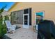 Relaxing back patio with rocking chairs, grill, and screened enclosure at 152 Travis Ln, Davenport, FL 33837