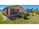 Backyard view of house with patio, landscaping, and a spacious lawn at 152 Travis Ln, Davenport, FL 33837