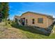 Backyard view of house with patio, landscaping, and a spacious lawn at 152 Travis Ln, Davenport, FL 33837