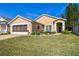 Tan house with double garage and landscaped yard at 152 Travis Ln, Davenport, FL 33837