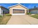 House exterior featuring a double garage and brick driveway at 152 Travis Ln, Davenport, FL 33837