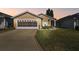 Tan house with a double garage and well-manicured lawn at 152 Travis Ln, Davenport, FL 33837