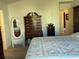 Bright bedroom with a decorative dresser, mirror, and a glimpse into an adjacent room at 2595 Edenville Path, The Villages, FL 32162