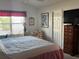 Relaxing bedroom with a soft-toned quilt, window and accent chair at 2595 Edenville Path, The Villages, FL 32162