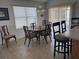 Dining area featuring an elegant wooden table, chairs, and window with sliding glass doors providing natural light at 2595 Edenville Path, The Villages, FL 32162