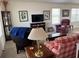 Cozy living room featuring a comfortable seating arrangement, framed artwork, and a wall-mounted television at 2595 Edenville Path, The Villages, FL 32162