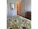 Bright main bedroom featuring floral bedding, closet, and mirrored accent piece at 2595 Edenville Path, The Villages, FL 32162