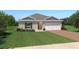 Charming single-story home with a well-manicured lawn, two-car garage, and brick driveway at 1534 Landon Ln, Haines City, FL 33844