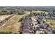 Aerial view shows the neighborhood homes, large green spaces, and surrounding wooded areas at 22004 Belgian Ct, Mount Dora, FL 32757