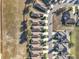 This aerial shot shows neatly arranged homes with driveways, a curving street, and a neighboring field, portraying an organized community at 22004 Belgian Ct, Mount Dora, FL 32757
