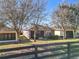 View of the backyard featuring a well-maintained lawn, mature trees, and a classic wooden fence at 22004 Belgian Ct, Mount Dora, FL 32757