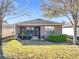 View of the backyard and patio showcasing a well-maintained lawn, mature trees, and a neat green hedge at 22004 Belgian Ct, Mount Dora, FL 32757