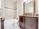 Well-lit bathroom featuring a vanity with dark wood cabinets, granite countertop, and a shower over tub with tiled walls at 22004 Belgian Ct, Mount Dora, FL 32757