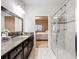 Bathroom featuring tiled glass shower, granite counters, and view into bedroom at 22004 Belgian Ct, Mount Dora, FL 32757