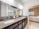 Elegant bathroom with double sinks, granite countertops, and a separate tiled shower at 22004 Belgian Ct, Mount Dora, FL 32757