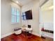 A well-lit bedroom displays hardwood floors, a shuttered window, and an open doorway to an adjoining room at 22004 Belgian Ct, Mount Dora, FL 32757